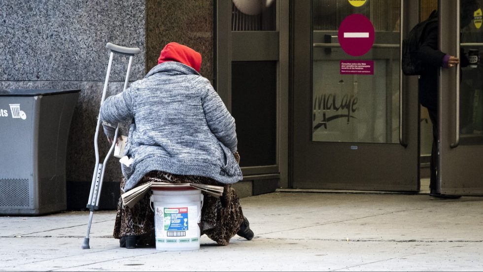 Une femme itinérante mendie devant le centre d'achats Alexis-Nihon pendant la pandémie de covid-19.