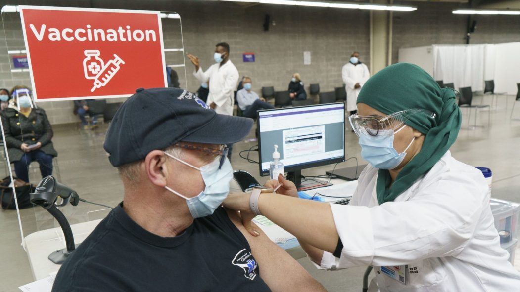 Un homme reçoit un vaccin à la clinique de vaccination du Stade olympique de Montréal.