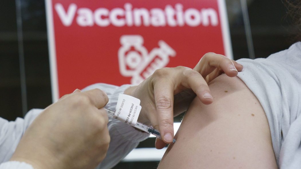 Une personne administre une dose de vaccin dans une clinique de vaccination