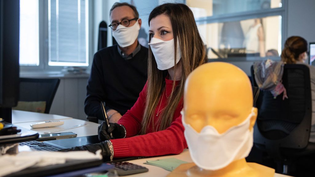 Des employés portent le masque médical.