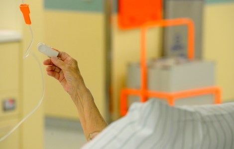 Une personne âgée hospitalisée pour la COVID-19 lève un bras.
