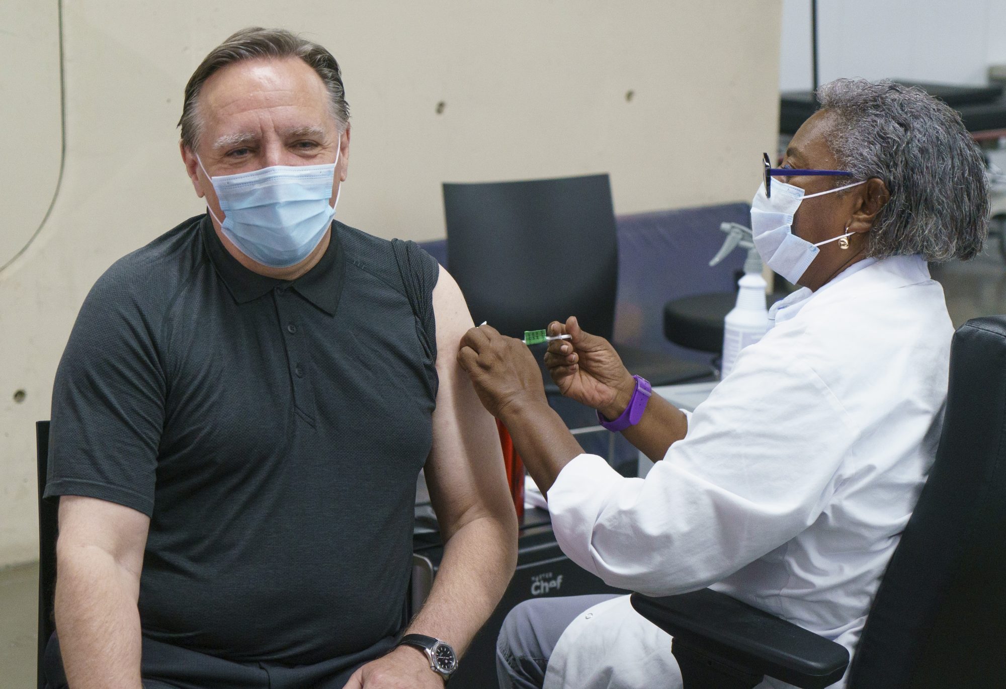 François Legault reçoit sa deuxième dose de vaccin de la part d'une infirmière.