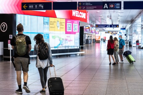 Des voyageurs à l'étage des départs à l'aéroport de Montréal.