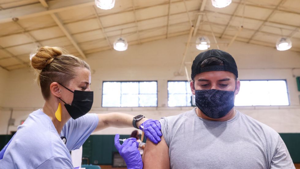 Une femme vaccine un homme.