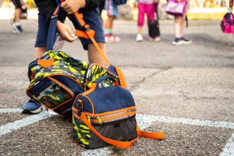Un enfant soulève son sac à dos lors de la rentrée scolaire dans une école de Montréal, pendant la pandémie de COVID-19.