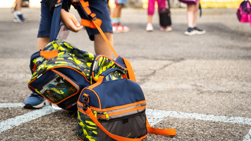 Un enfant soulève son sac à dos lors de la rentrée scolaire dans une école de Montréal, pendant la pandémie de COVID-19.