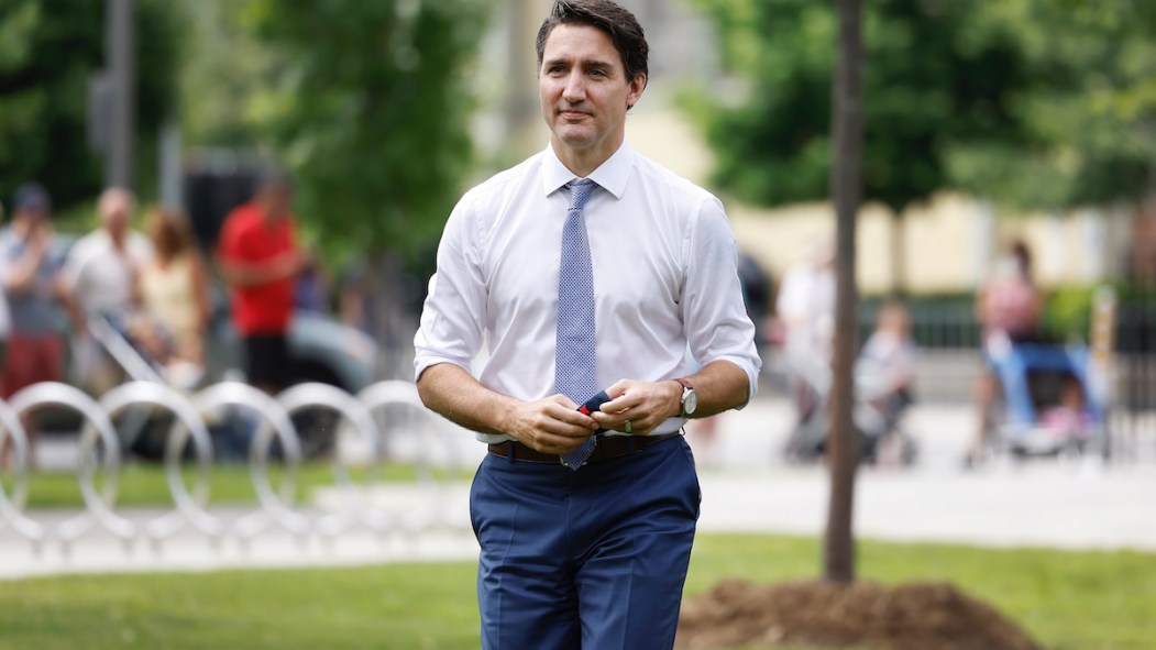 Le premier ministre Justin Trudeau en chemise et cravate, se promenant dans un parc l'été peu avant les élections fédérales 2021.