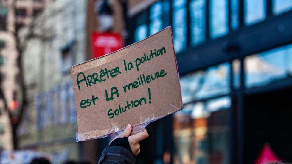 Une main tient une affiche disant «arrêter la pollution est la meilleure solution» lors d'une manifestation pour la lutte aux changements climatiques tenue à Montréal