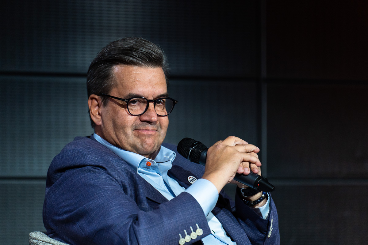 Denis Coderre tient un microphone devant fond noir