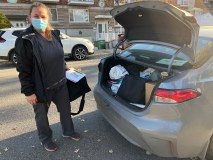 Isabelle Roy devant le coffre de sa voiture.