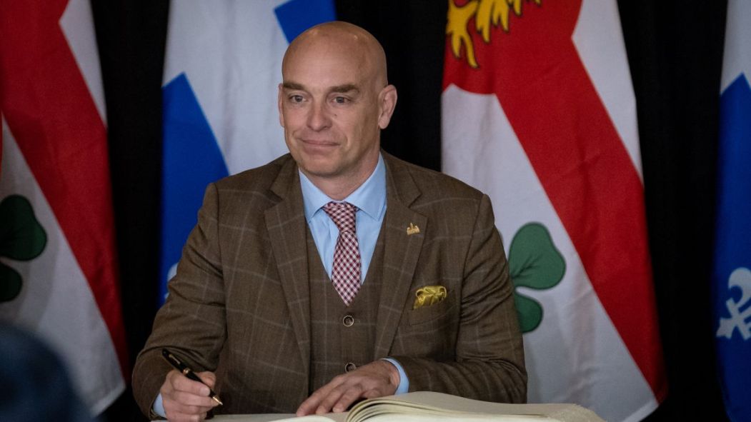 Alain Vaillancourt est assermenté comme responsable de la sécurité publique du comité exécutif de Montréal, devant des drapeaux de Montréal et du Québec.