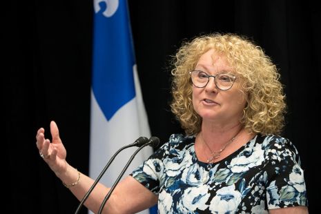 Marguerite Blais, ministre des Aînés et des Proches aidants, prononce un discours devant un drapeau du Québec.
