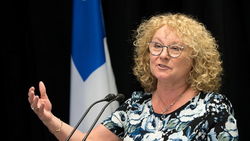 Marguerite Blais, ministre des Aînés et des Proches aidants, prononce un discours devant un drapeau du Québec.