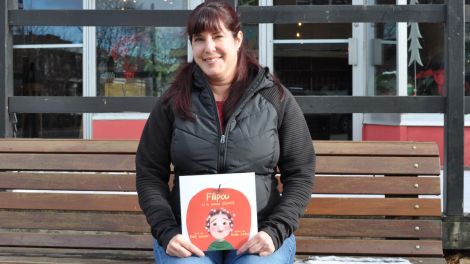 &Eacute;dith Lacroix tient dans ses mains son livre pour la recherche du syndrome de Hunter.