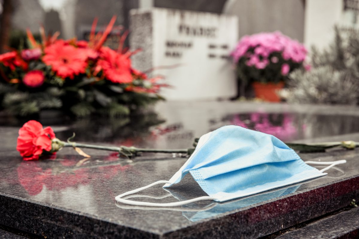 masque covid-19 sur une tombe représentant le nombre de mort et de victimes du à la pandémie