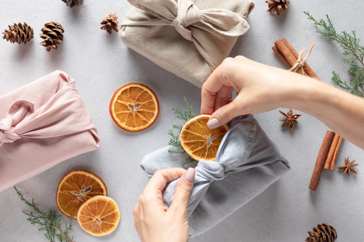 Une femme pratiquant le furoshiki. C'est une technique parfaite pour emballer ses cadeaux sans déchets !