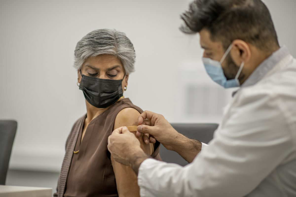 une femme se fait vacciner par un médecin