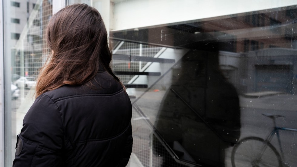 Une femme vaccinée vue de dos, dehors.