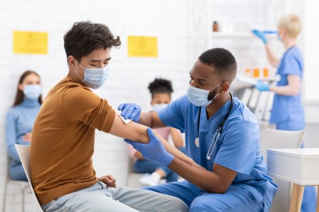 un homme se fait vacciner par un infirmer contre la covid-19