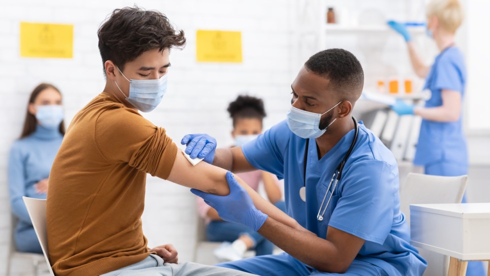 un homme se fait vacciner par un infirmer contre la covid-19