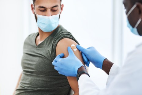 un homme se fait vacciner par un infirmier