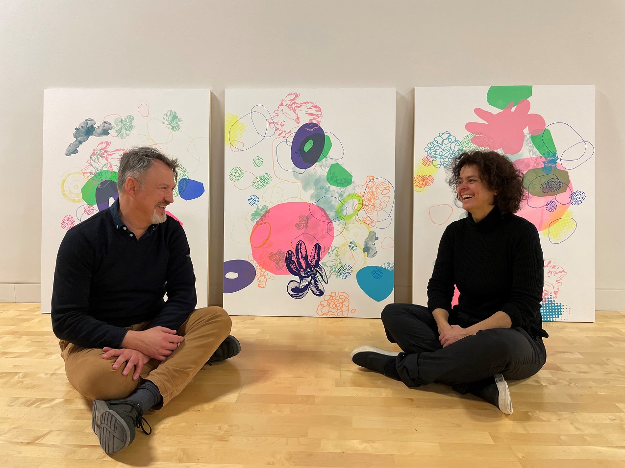 Les artistes devant trois de leurs oeuvres au Centre d'exposition Lethbridge