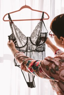 Une femme tenant une pièce de lingerie.