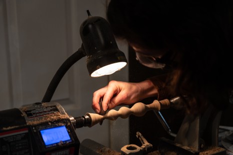Un participant &agrave; un atelier de fabrication de dildo utilisant le tour &agrave; bois.