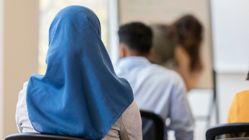 femme de dos, en classe à l'école, qui porte le voile, hidjab