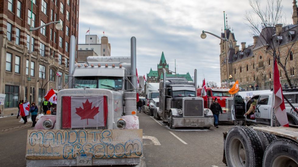 Arrivée de la manifestation de camionneurs nommée convoi de la liberté au centre-ville d'Ottawa. Plusieurs camions affichent des drapeaux canadiens.