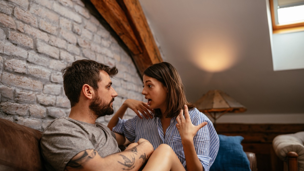 Un homme et femme argumentent sur un canapé.