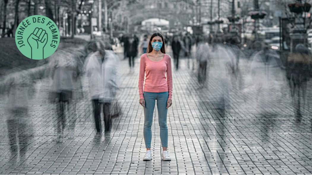 Une femme se tient au milieu d'une rue passante.