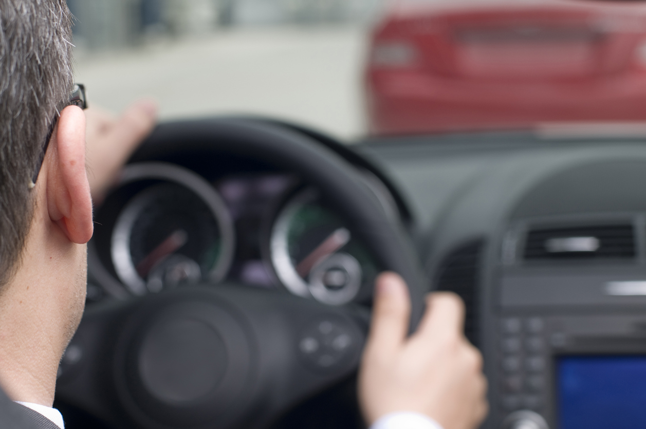 Un homme conduit derrière une autre voiture.