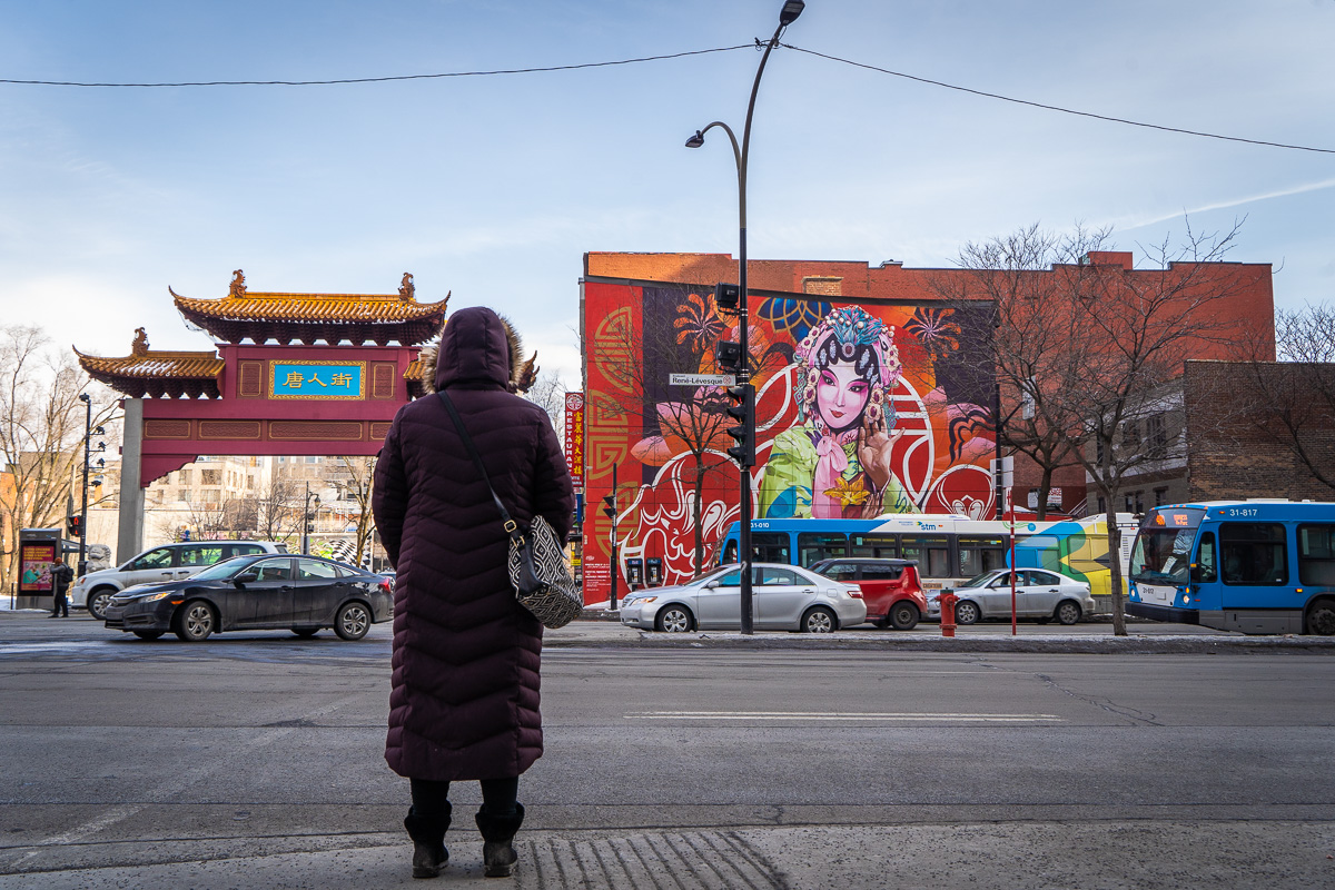 Une femme se prépare à traverser la rue à l'entrée du Quartier chinois de Montréal.