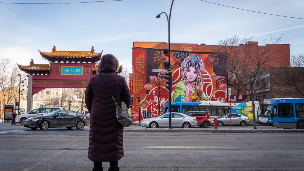 Une femme se prépare à traverser la rue à l'entrée du Quartier chinois de Montréal.