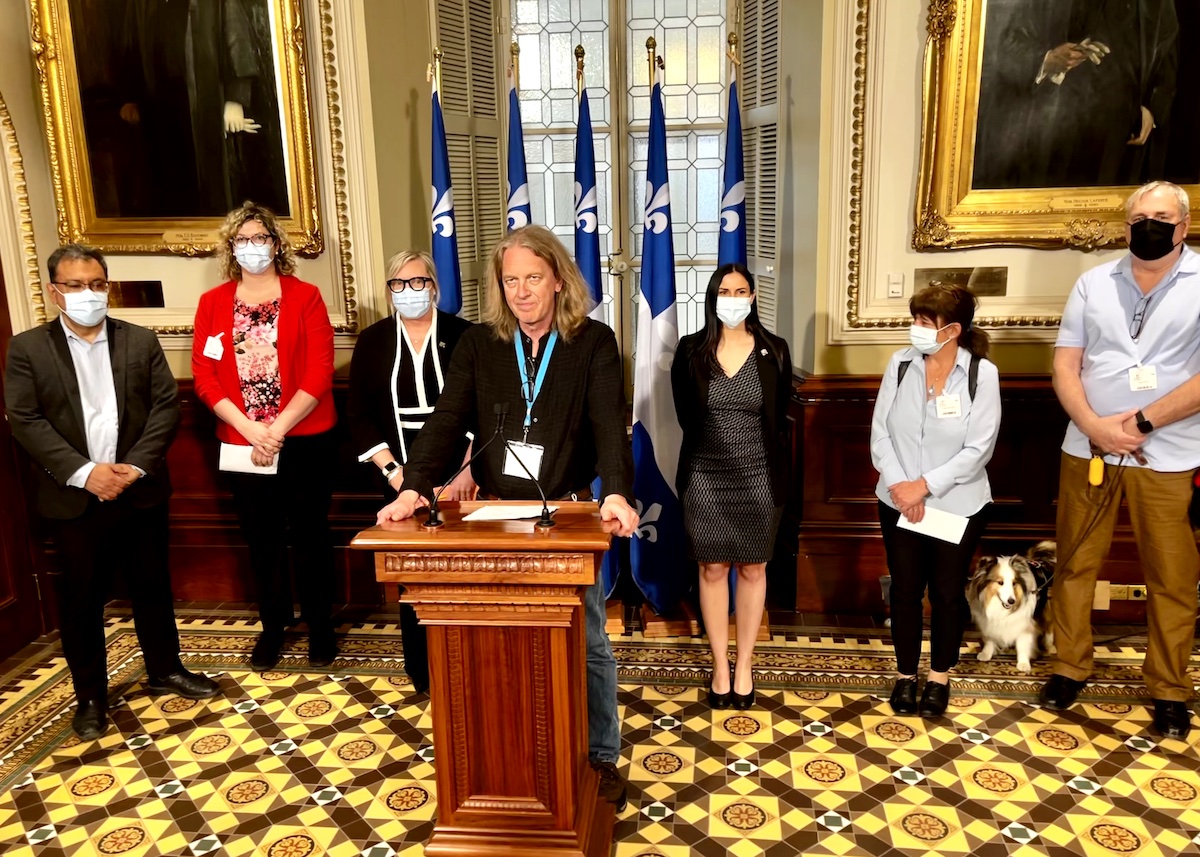 Le président du Réseau québécois des OSBL d'habitation, André Castonguay, entouré de députés et d'autres représentants du RQOH.