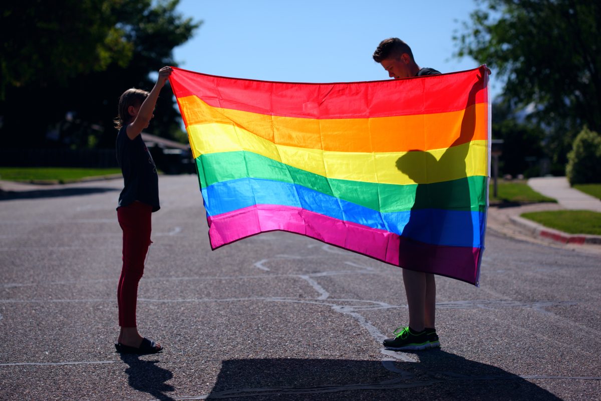 Des personnes tenant le drapeau LGBTQ+.