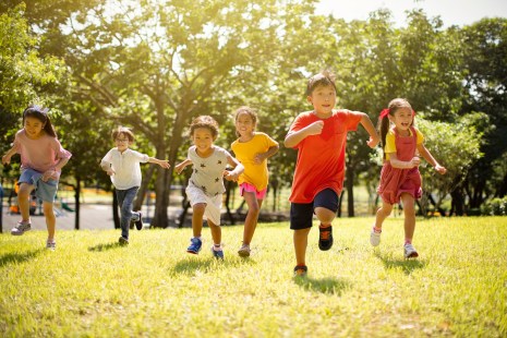 Des enfants courent dans un parc ensoleillé