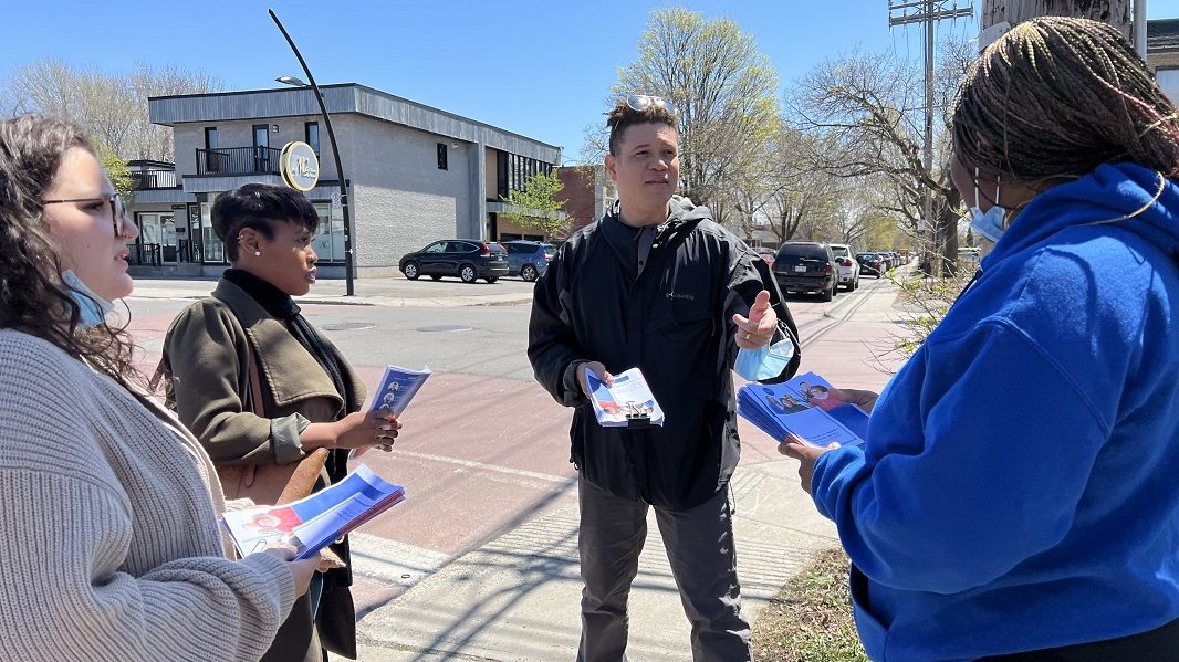 Les quatre chargés de mobilisation en cercle sur un trottoir.