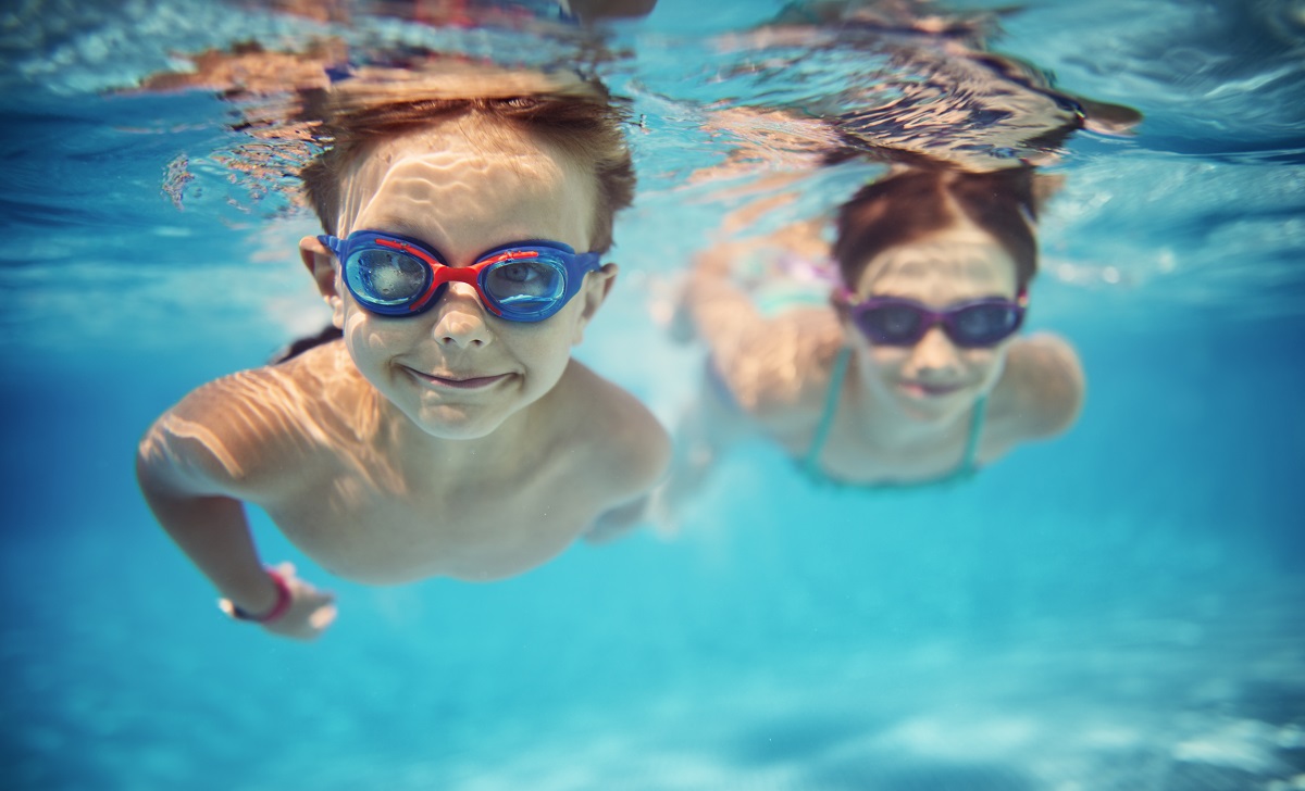 Deux enfants nagent sous l'eau