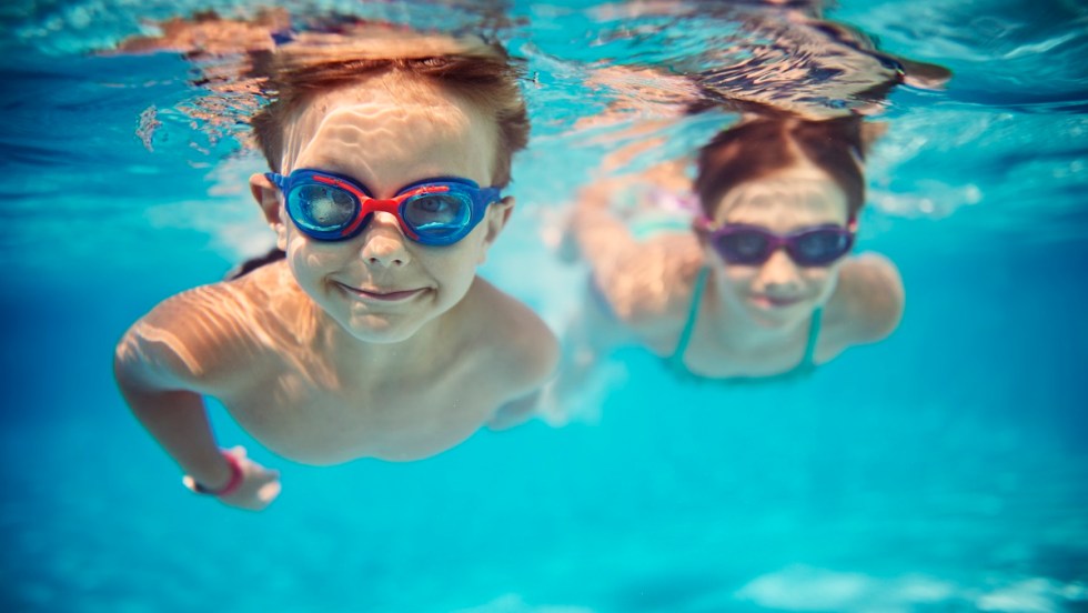 Deux enfants nagent sous l'eau