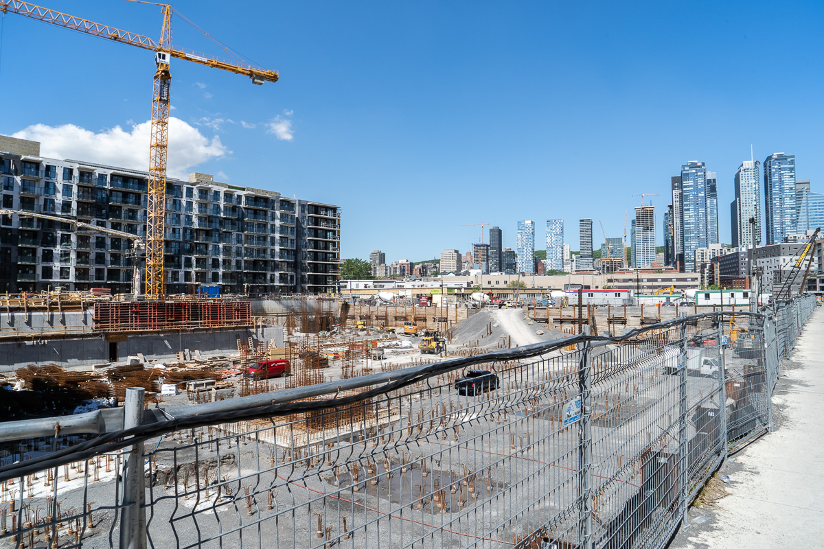 Près d'un chantier de Griffintown, des grues sont visibles autour des grattes-ciel du centre-ville de Montréal.