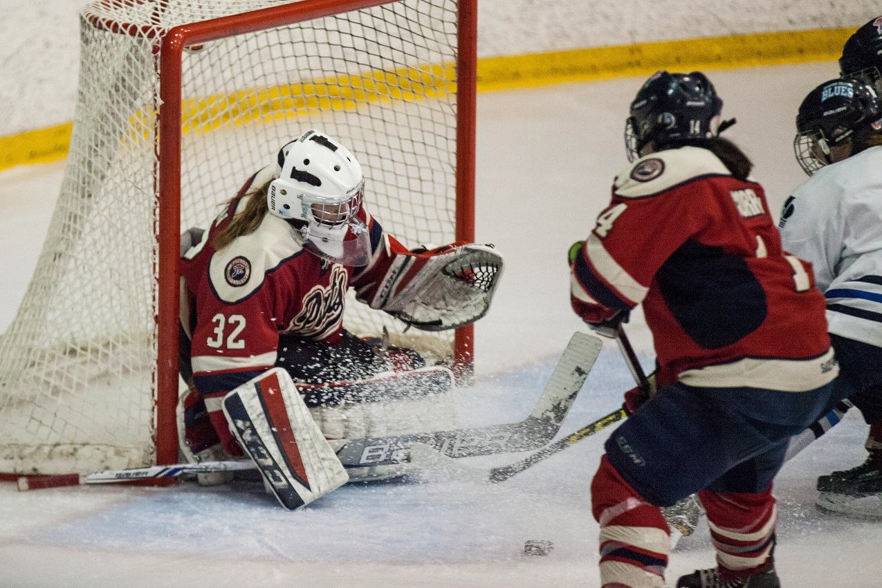 La gardienne de but de l'équipe de hockey féminin des Patriotes du Cégep de Saint-Laurent, dont l'avenir est incertain, effectue un arrêt pendant un match.
