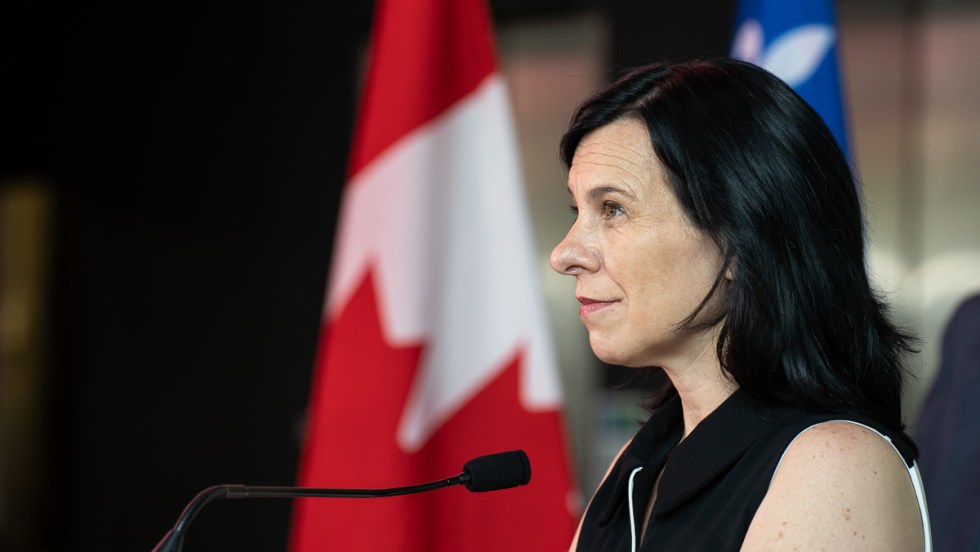 Valérie Plante devant des drapeaux du Québec et du Canada