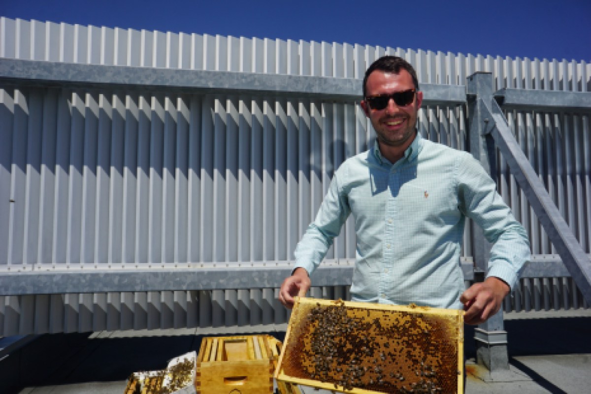 Sébastien Jordan tenant un cadre de ruche.