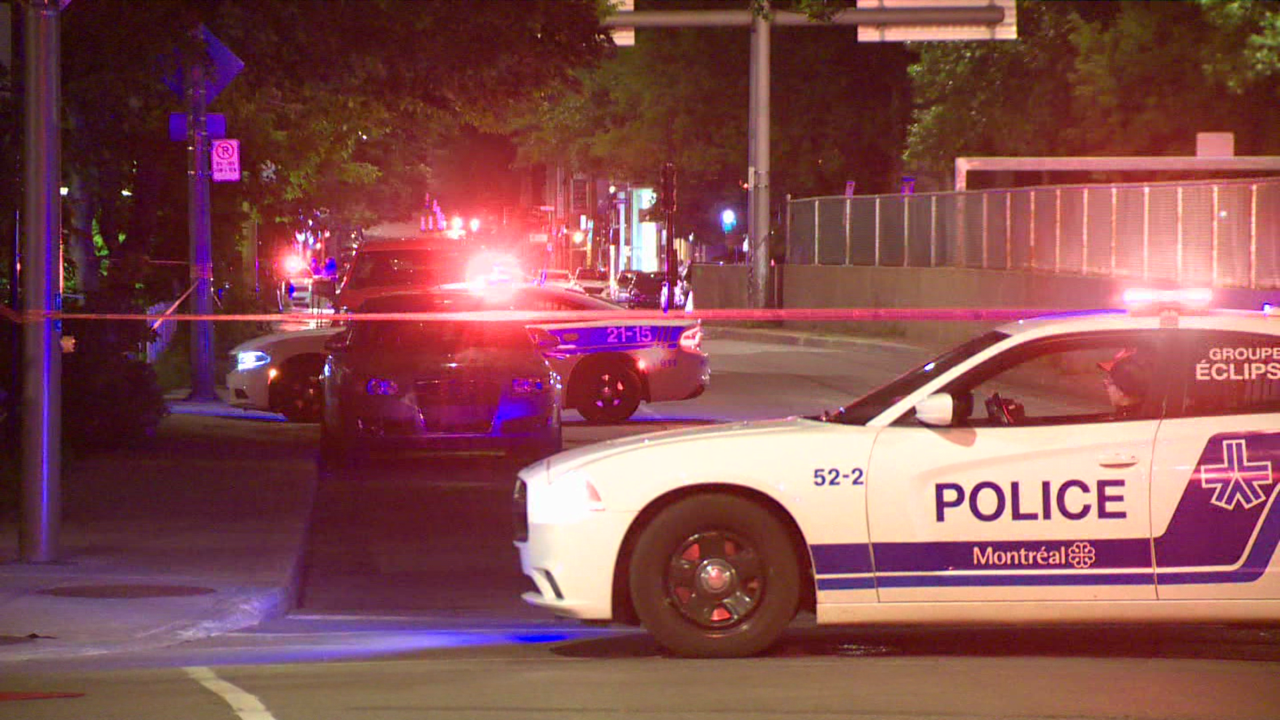 Une scène de crime est délimitée par un cordon et par plusieurs véhicules de police après qu'un policier du SPVM ait été atteint par un coup de feu.