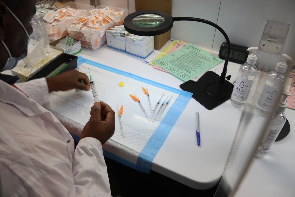 Un homme préparant les doses de vaccin.