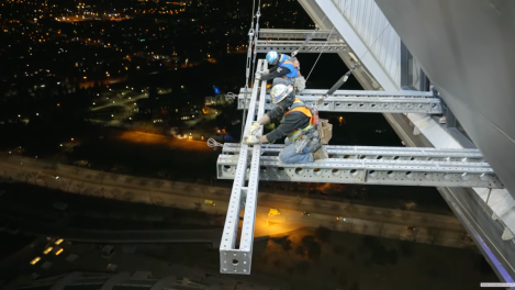 Les rénovations de la Tour de Montréal ont requis que des ouvriers construisent un échafaudage dans le vide.