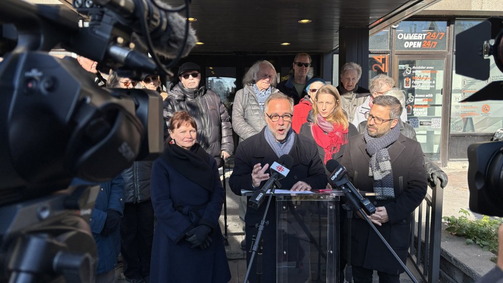 Luc Rabouin et Robert Beaudry devant la Résidence Mont-Carmel, accompagnés de plusieurs résidents.