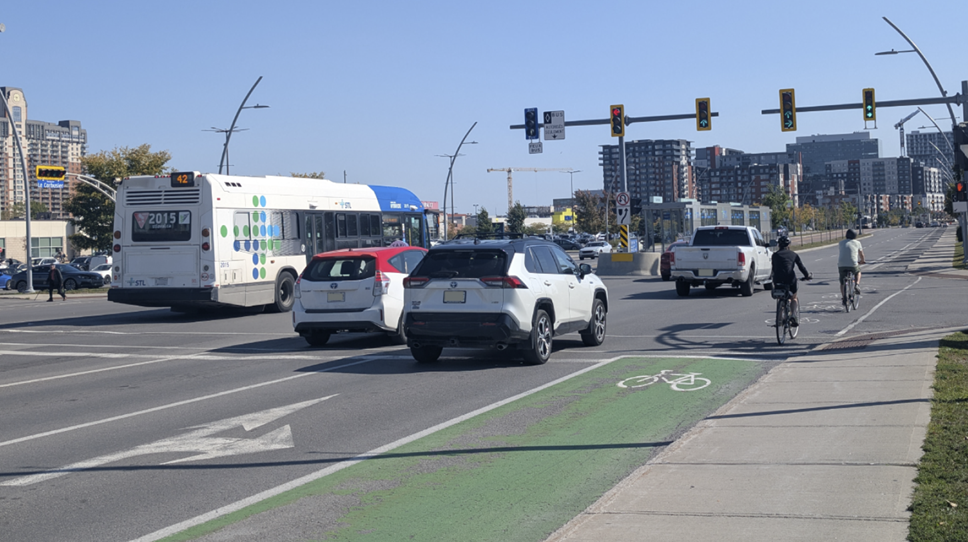 Un axe de transport à Laval comprenant des pistes cyclables, des voies pour les voitures et une voie pour les autobus.